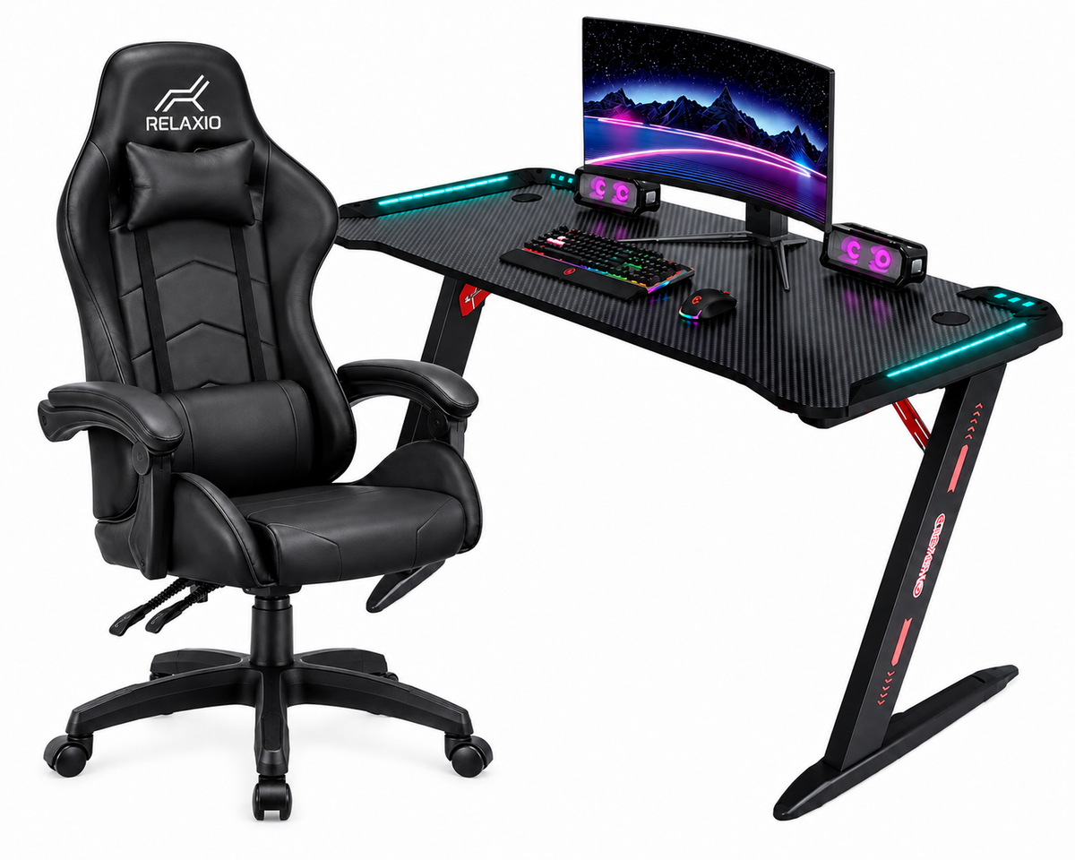 A black gaming chair with a matching curved desk setup, including a monitor, keyboard, mouse, and RGB lighting, shown on a clean white background.