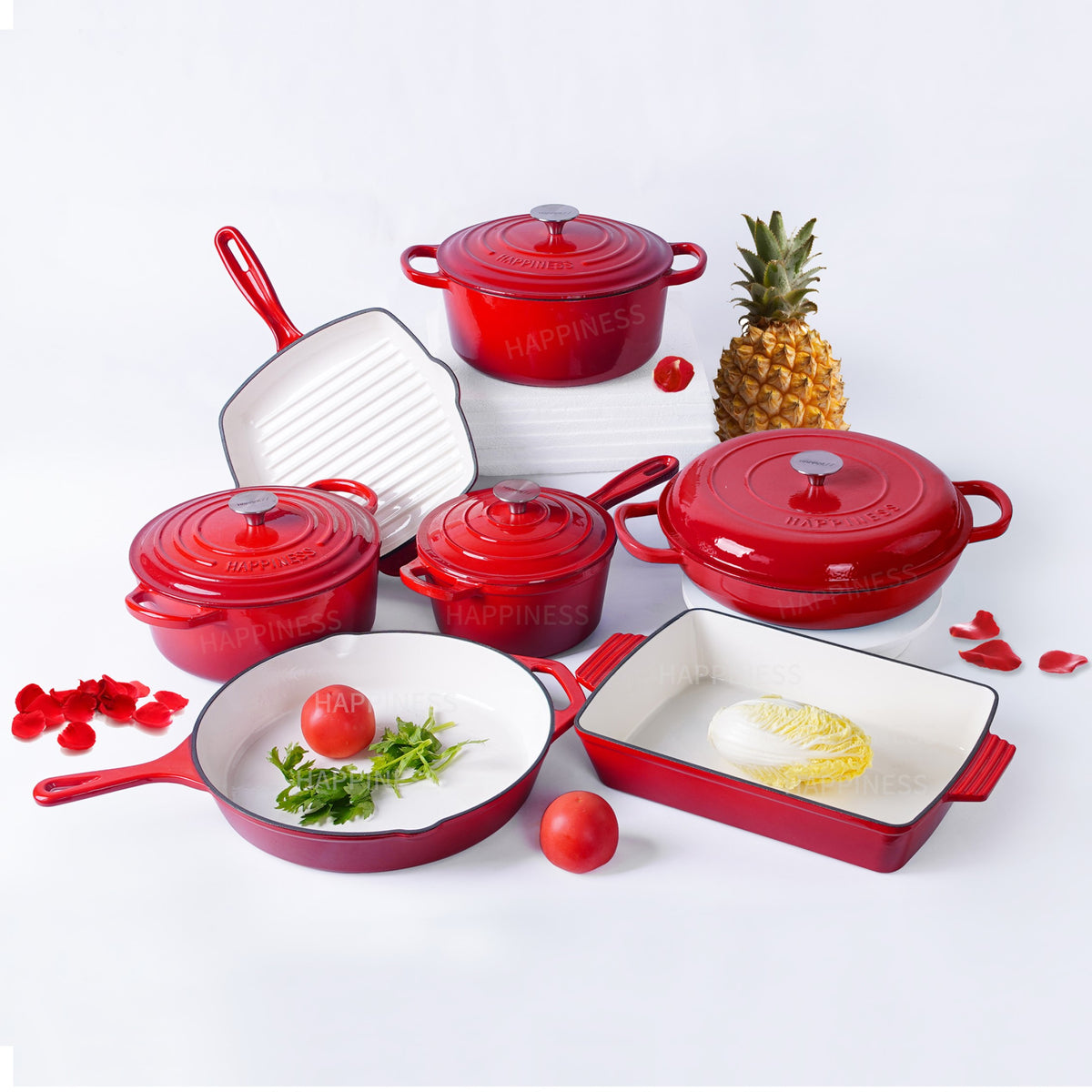 Set of red cookware with white interiors on a light gray background