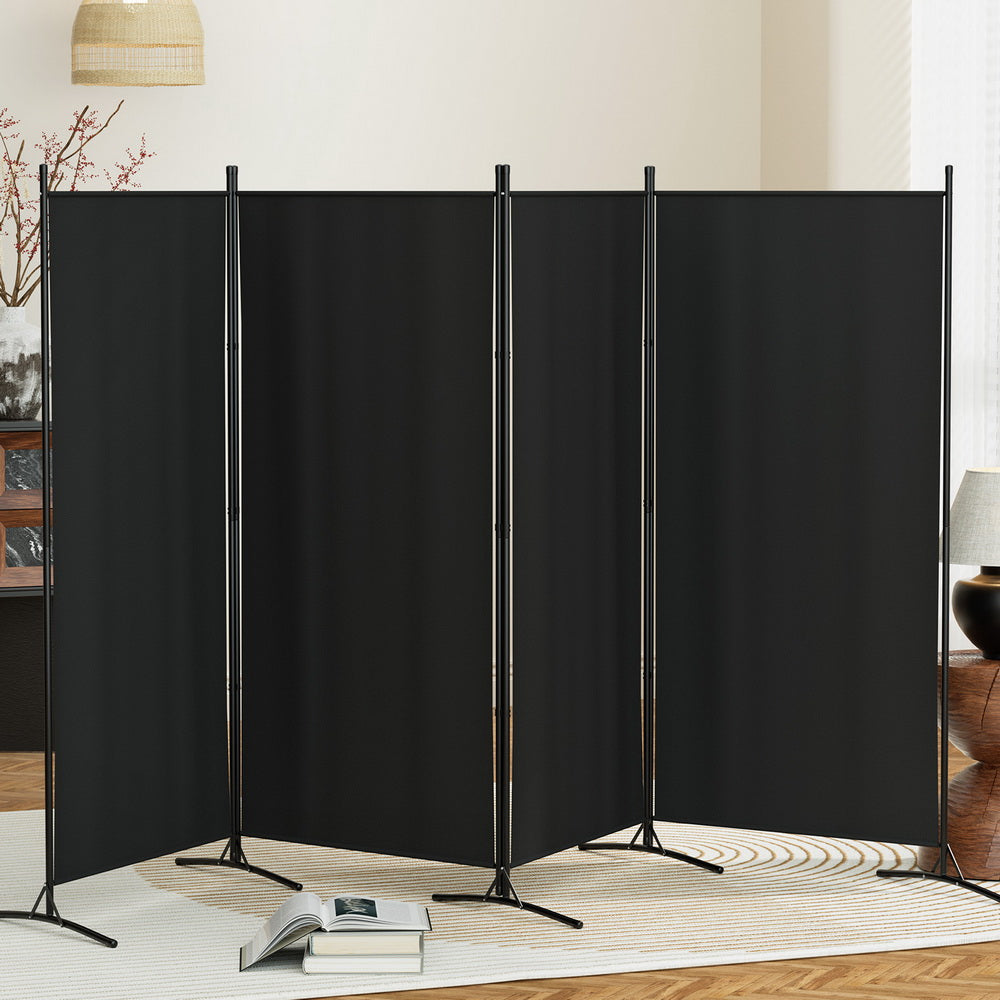Black room divider screen in a living room setting with books and decor.