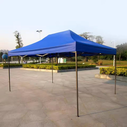 Blue canopy tent on a stone pavement with greenery in the background